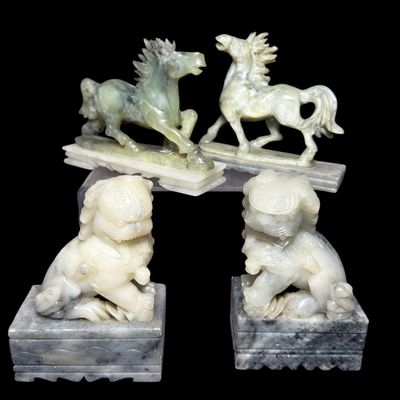 A Group of Four Chinese Carved Stone Figurines Including a Pair of Guardian Lions and a Pair of Charging Horses