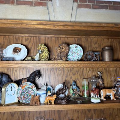A Collection of Decorative Animal Figurines, Commemorative Plates, and a Howard Miller Songbird Clock