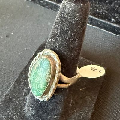 Vintage Southwestern-style sterling silver ring featuring an oval green turquoise cabochon with a twisted rope border, displayed on a...