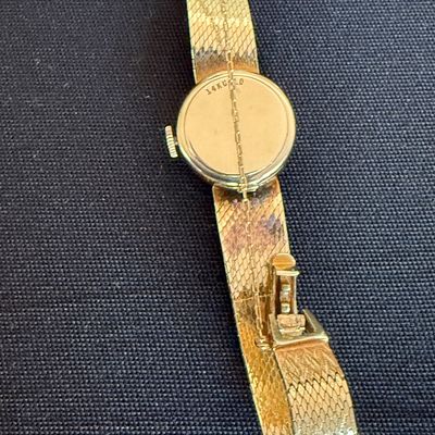 Vintage ladies' 14k gold wristwatch with a textured mesh band, showing the "14K GOLD" stamp on the case back.