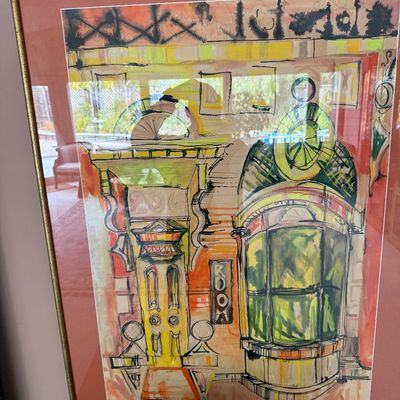 Framed mixed-media architectural sketch depicting a storefront or building facade, rendered in watercolor and ink with a warm color...