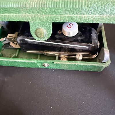 Vintage Singer Sewhandy model 20 miniature sewing machine, housed in its original green textured carrying case.