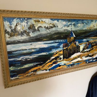 Impasto oil painting depicting Sevanavank monastery on the shore of Lake Sevan, dated 1990, housed in an ornate gold-finished frame.