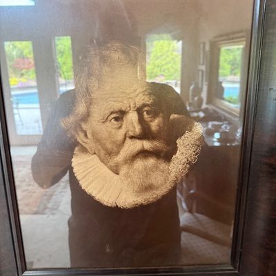 Framed sepia-toned portrait print of an older man with a beard and ruff collar, housed in a dark wood frame.