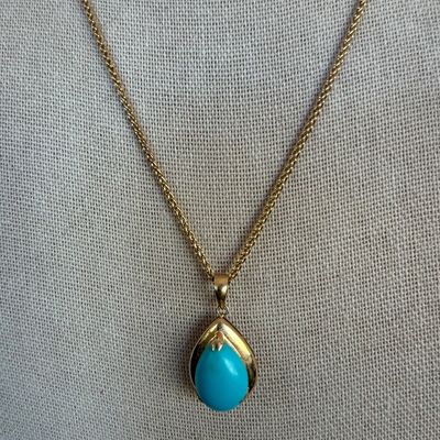Vintage gold chain necklace featuring a teardrop-shaped pendant set with a vibrant turquoise cabochon.