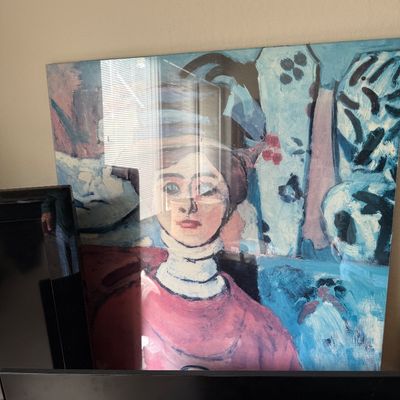 Large framed expressionist-style portrait print of a woman in a hat, rendered in a cool blue and pink color palette.