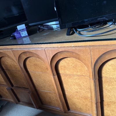 Mid-century modern wooden credenza featuring a distinctive carved arch design on the drawer fronts and a glass top protector.