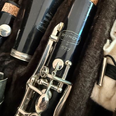Vintage Bundy 577 clarinet disassembled in its original plush-lined hard case, showing the maker's mark and silver-plated keys.