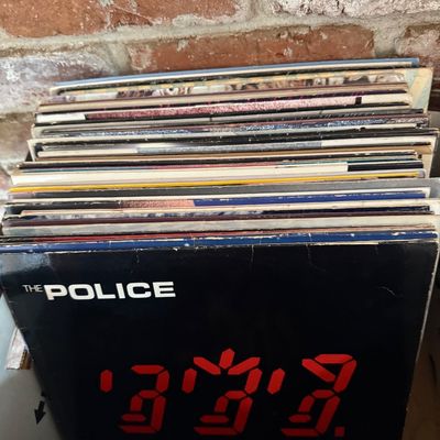 Stack of vintage vinyl records, featuring The Police's 1981 album "Ghost in the Machine" at the front.