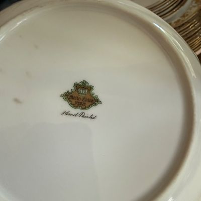 Underside of a Meito China plate showing the "Hand Painted" maker's mark with a crown logo, made in Japan.