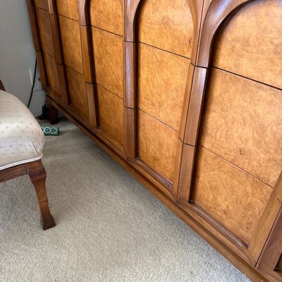 Mid-century modern wooden credenza featuring a distinctive carved arch design on the cabinet doors and drawer fronts.
