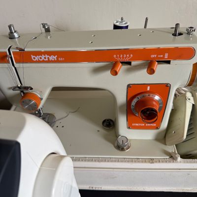Vintage Brother 681 sewing machine featuring a cream-colored body with retro orange accents and stretch stitch controls.