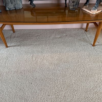 Mid-century modern surfboard coffee table with tapered legs and a protective glass top.