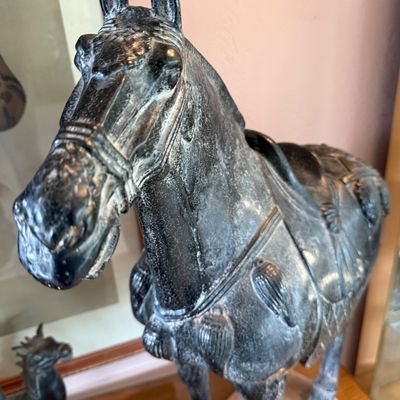 Vintage Tang dynasty style ceramic horse statue with a distressed black glaze finish and detailed saddle and harness.