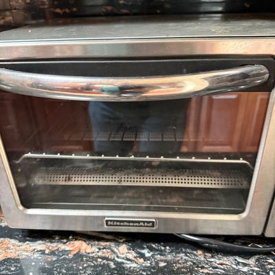 KitchenAid stainless steel countertop toaster oven, showing some signs of light use.