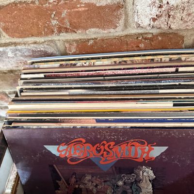 Aerosmith self-titled debut vinyl record album, released in 1973, shown at the front of a stack of vintage LPs.