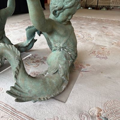 Verdigris patinated bronze merman or triton table base, featuring a detailed mythological figure with a fish tail supporting a glass top.