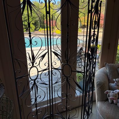 Vintage three-panel wrought iron folding screen featuring intricate scrollwork and leaf motifs.