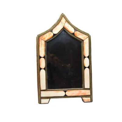 Vintage Anglo-Indian arched tabletop mirror featuring a brass frame inlaid with bone and dyed orange-pink accents.