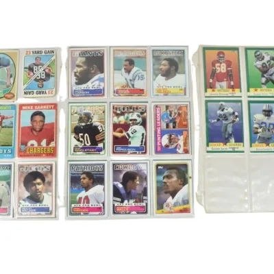 Collection of vintage NFL trading cards from the 1970s and 1980s, housed in plastic binder sleeves.