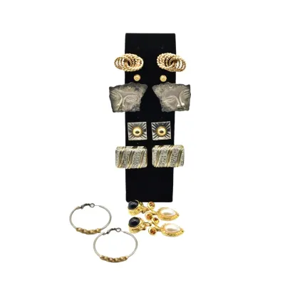 Assortment of vintage fashion earrings, featuring gold-toned hoops, textured studs, rhinestone-accented pieces, and unique carved face...
