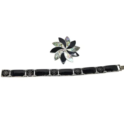 Vintage Mexican sterling silver jewelry set, featuring a pinwheel brooch with abalone shell and black onyx inlay, paired with a matching...