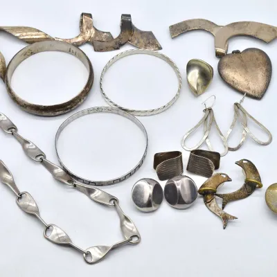 Assortment of vintage sterling silver jewelry and accessories, including bangle bracelets, a link necklace, earrings, and a decorative...