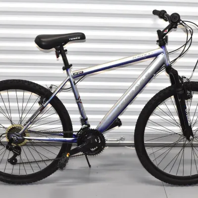 Kent Terra 2.6 mountain bike featuring a silver and blue aluminum frame, front suspension fork, and Shimano components.