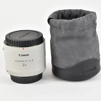 Canon Extender EF 2x III teleconverter with front and rear caps, shown alongside its original grey suede drawstring pouch.