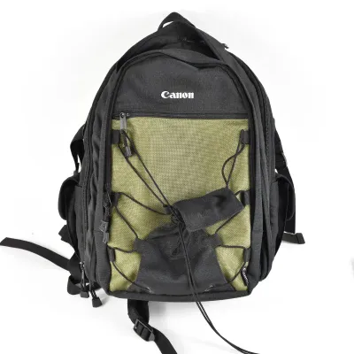 Canon camera backpack in black and olive green, featuring multiple zippered compartments and an exterior bungee cord system.