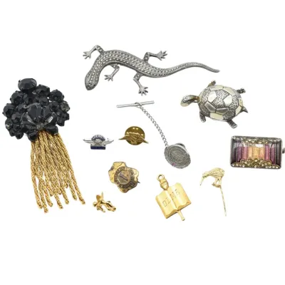 Assortment of vintage costume jewelry and pins, featuring a marcasite lizard brooch, a turtle brooch, a black rhinestone tassel brooch,...