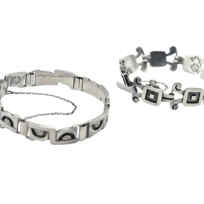 Two vintage Mexican sterling silver link bracelets, featuring geometric and scroll motifs with safety chains.