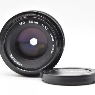 Vintage Minolta MD 50mm f/1.7 manual focus camera lens with a 49mm filter thread, shown with its front lens cap.