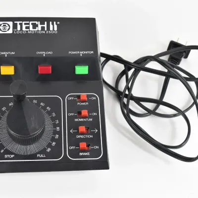 Vintage MRC Tech II Loco-Motion 2500 train controller with power cord, featuring a large throttle dial and toggle switches.