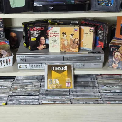 Magnavox 4-head VCR and DVD player combo unit, surrounded by a collection of classical music CDs, opera box sets, and a drawer filled...