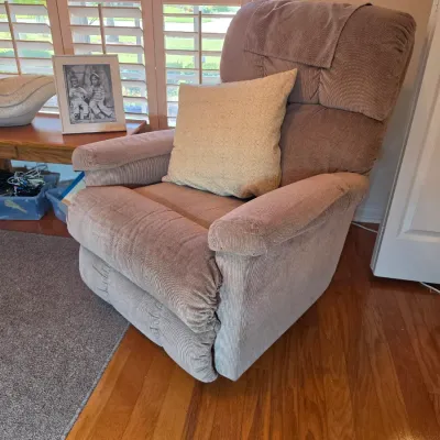 Plush corduroy recliner in a neutral taupe shade, paired with a light-colored accent pillow.