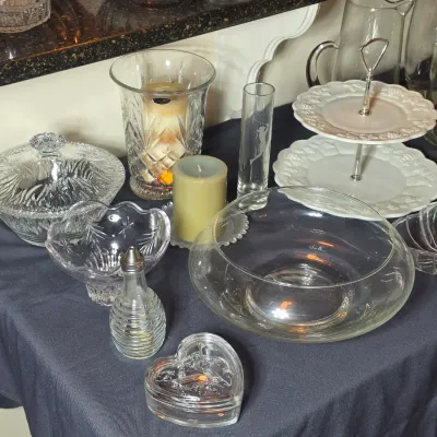 Assorted glassware and serving pieces, including a cut-glass lidded dish, a two-tiered white ceramic server, a large clear glass bowl,...