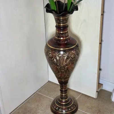 Vintage etched brass floor vase with a ruffled rim, featuring intricate floral and scrollwork designs in gold and dark red tones.