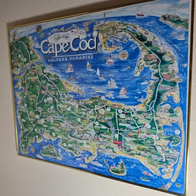 Framed "Cape Cod Golfers' Paradise" illustrated map poster, featuring colorful details of local golf courses and landmarks...