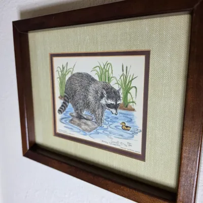 Framed and matted limited edition print titled "Raccoon" by Philip Leonetti, numbered 312/500 and dated 1976, featuring a...