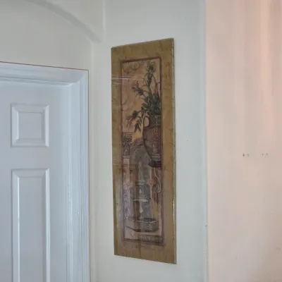 Tuscan-style vertical wall art panel featuring a classic fountain and floral urn motif in warm, neutral tones.