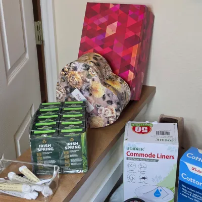 Assortment of household items including Irish Spring bar soap, Walgreens cotton balls, commode liners, shoelaces, and decorative gift boxes.