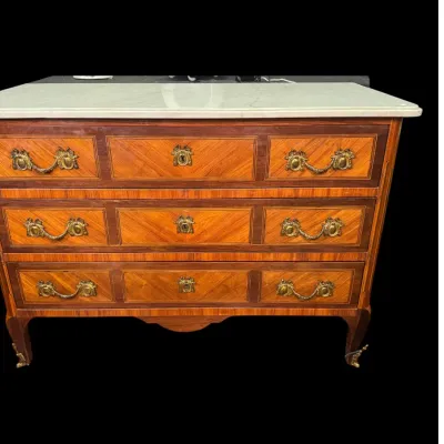 French Louis XV style three-drawer commode featuring parquetry wood inlay, ornate brass hardware, and a white marble top.
