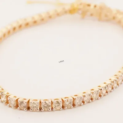 Classic gold tennis bracelet featuring a continuous line of round-cut diamonds in individual four-prong settings.