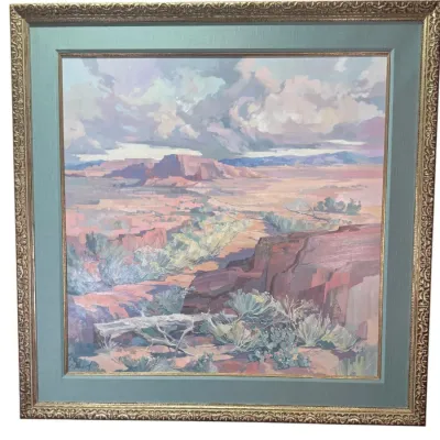 Impressionistic desert landscape oil painting depicting mesas and sagebrush, housed in a wide sage green mat and an ornate gilt frame.