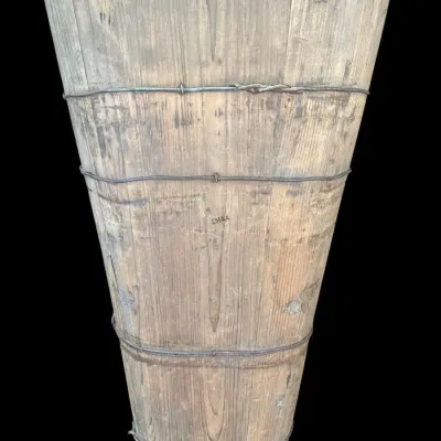Rustic antique wooden stave bucket with a tapered design, bound by twisted wire bands.