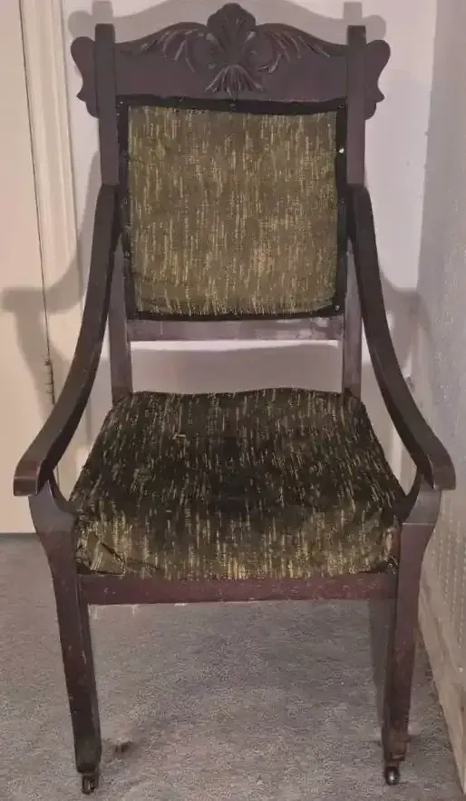 Antique Wooden Armchair Featuring a Carved Floral Crest and Olive-Green Textured Upholstery 