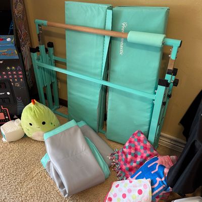 Foldable Gymnastics Bar with a wooden rail and folded exercise mats