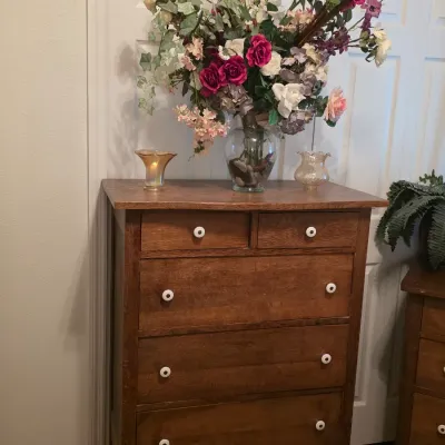 Antique oak tallboy dresser featuring two small top drawers and three full-width lower drawers, accented with white ceramic knobs.
