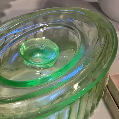 Vintage green depression glass lidded butter dish with a ribbed base and oval lid.